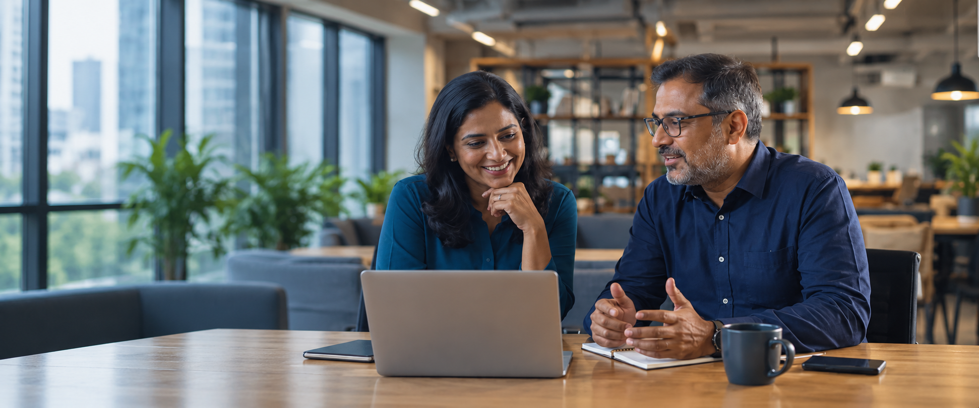 Two business professionals discussing work at a laptop